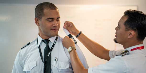 Man receiving pilot stripes