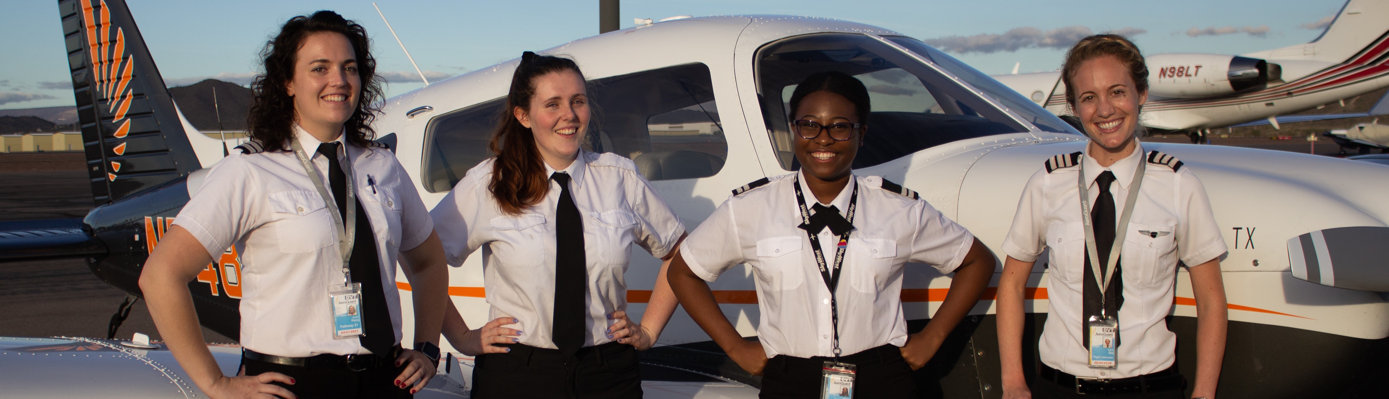 Four female pilots standing in front of an aircraft.